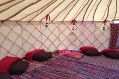 brown bean bags, red blankets and lanterns on rag rugs