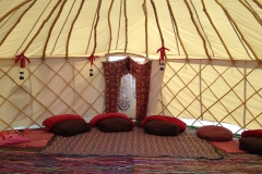 brown bean bags, red blankets and lanterns on rag rugs with door decoration